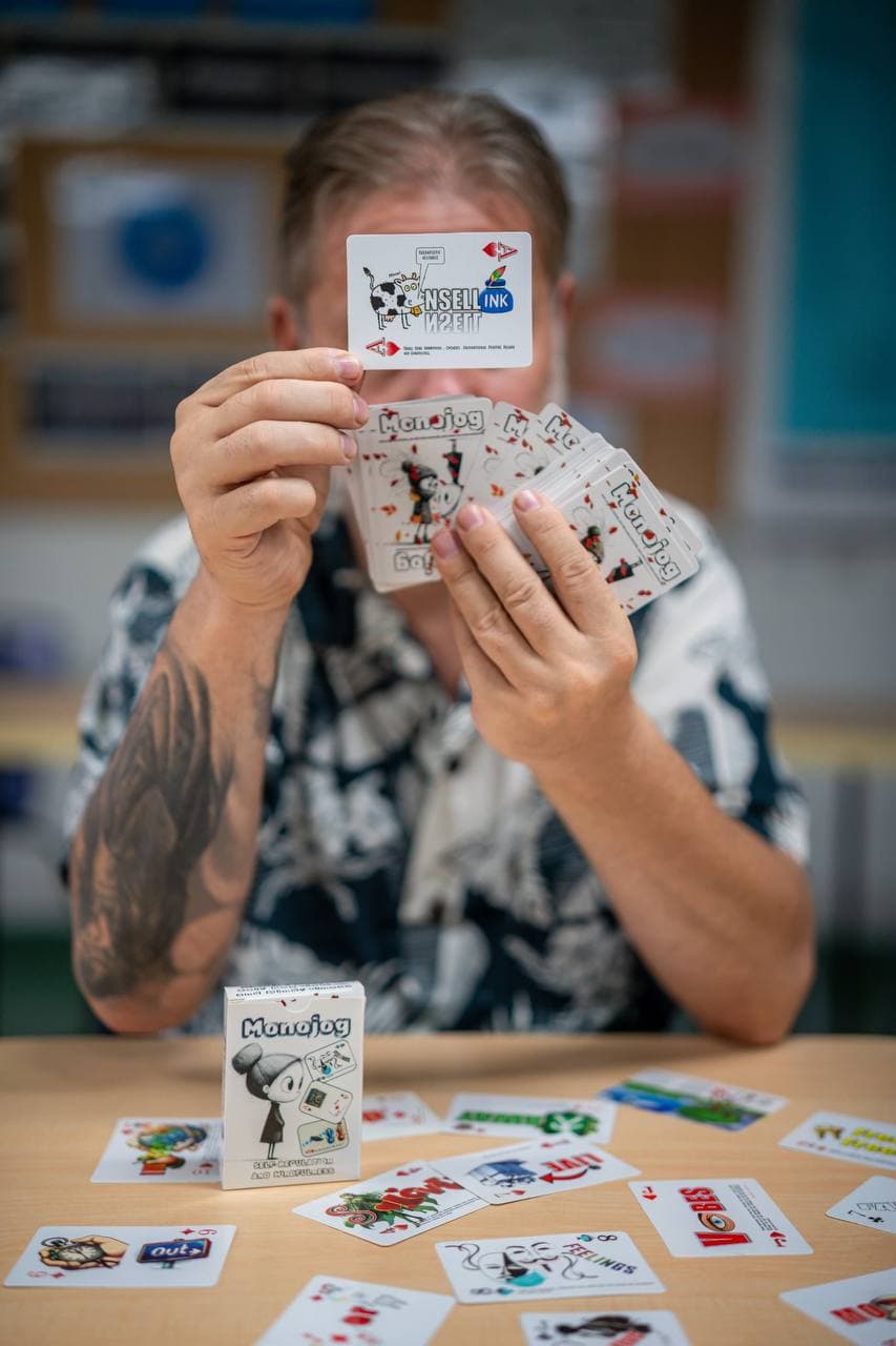 Joe holding up cards from the reflection card deck, with more cards spread across the table